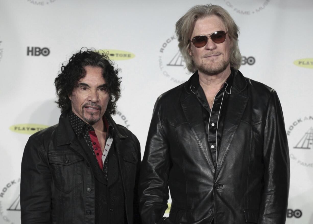 FILE - Hall of Fame Inductees, Hall &amp; Oates, John Oates and Daryl Hall appear in the press room at the 2014 Rock and Roll Hall of Fame Induction Ceremony on April, 10, 2014, in New York.  Hall has sued his longtime music partner John Oates, arguing that his plan to sell off his share of a joint venture would violate a business agreement the duo had.