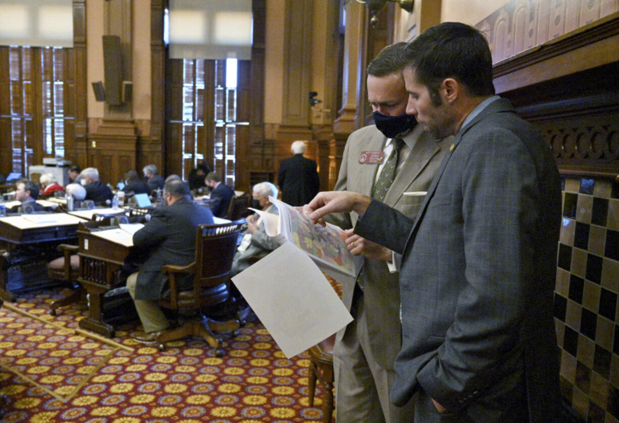 FILE - Georgia state Reps. Matt Dubnik, R-Gainesville, left, and Timothy Barr, R-Lawrenceville, confer over a redistricting map at the Georgia State Capitol in Atlanta on Wednesday, Nov. 10, 2021. Lawmakers will return on Wednesday, Nov. 29, 2023, for a special session to redraw congressional and legislative maps after a federal judge ruled Georgia&rsquo;s maps illegally diluted the power of Black voters.