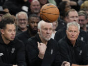 San Antonio Spurs head coach Gregg Popovich, center, flips the ball back to an official during the second half of a preseason NBA basketball game against the Houston Rockets in San Antonio, Monday, Oct. 16, 2023.