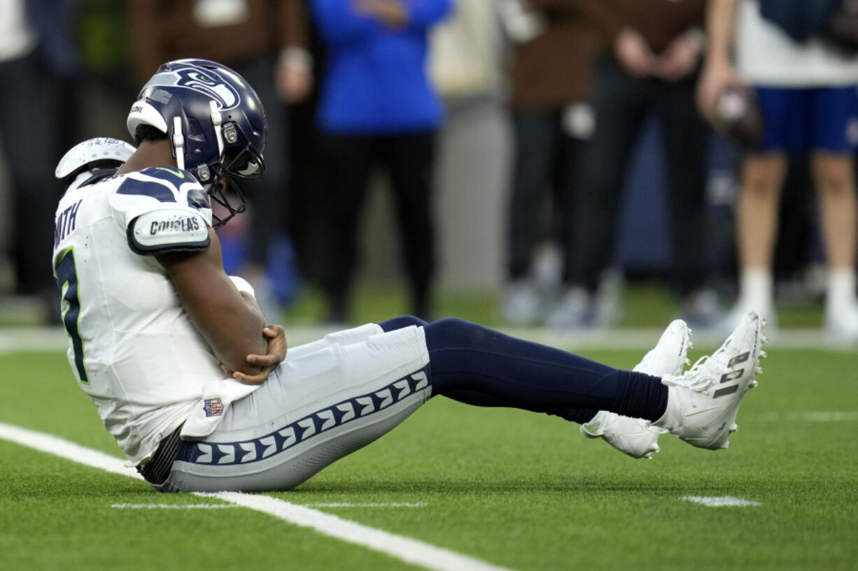 Seattle Seahawks quarterback Geno Smith (7) sits on the field after being injured during the second half of an NFL football game against the Los Angeles Rams Sunday, Nov. 19, 2023, in Inglewood, Calif.