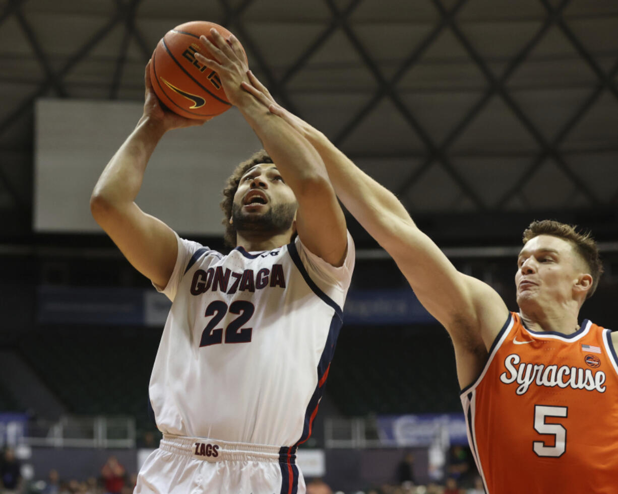 Gonzaga forward Anton Watson (22) goes to the net over Syracuse guard Justin Taylor (5) during the first half of an NCAA college basketball game, Tuesday, Nov. 21, 2023, in Honolulu.