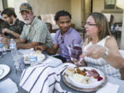 Jamal Hinton, center, Wanda Dench, right, and her family and friends, have Thanksgiving dinner at Dench&rsquo;s home on Nov. 24, 2016, in Mesa, Ariz.