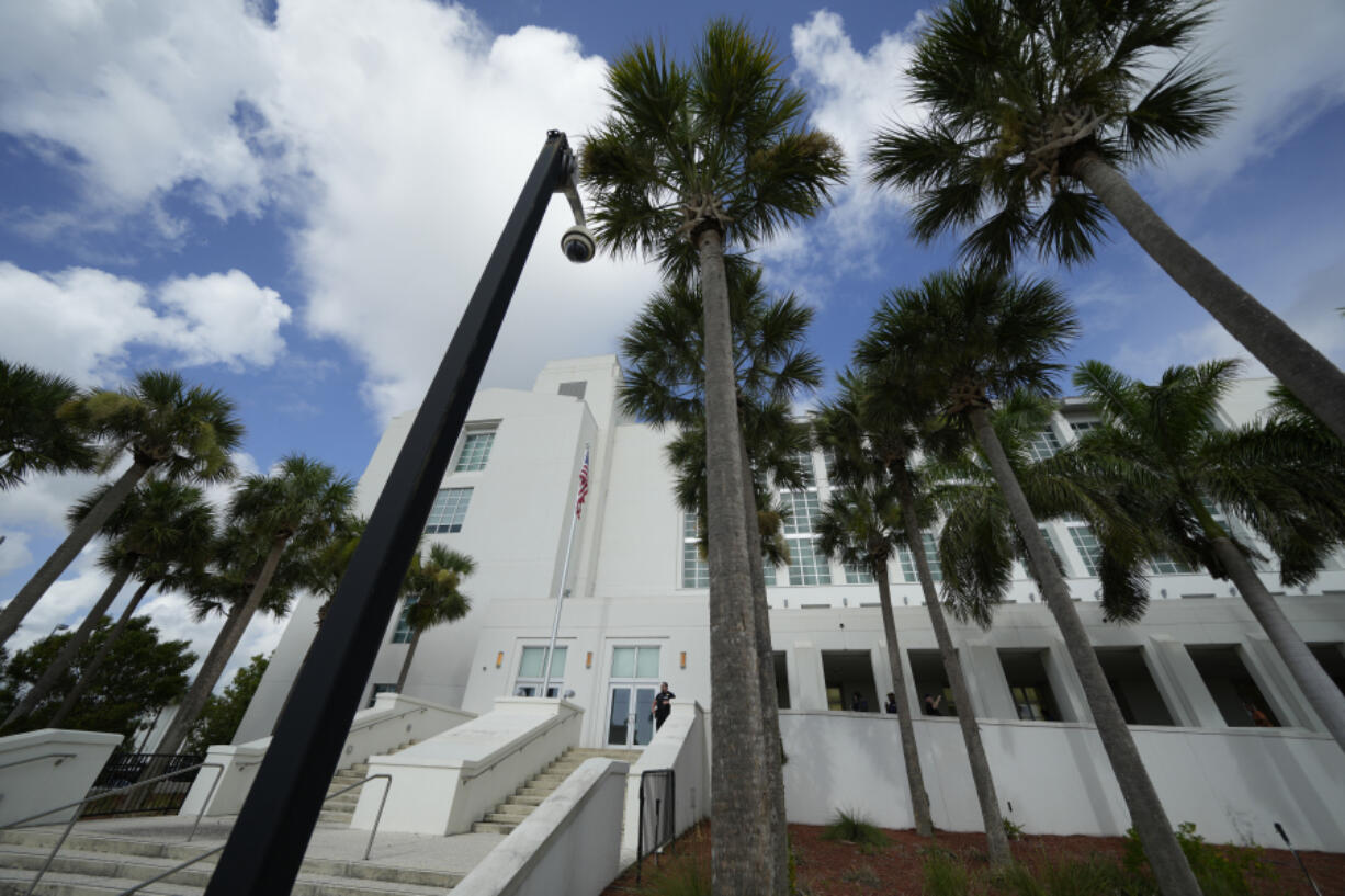 FILE - A police officer stands beside an entrance to the Alto Lee Adams Sr. U.S. Courthouse, Aug. 15, 2023, in Fort Pierce, Fla. A federal judge in Florida has indicated she may delay the start of former President Donald Trump&rsquo;s trial on charges that he hid classified documents at Mar-a-Lago. U.S. District Judge Aileen Cannon questioned prosecutors Wednesday about whether starting the trial in May as scheduled is feasible.