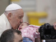 Pope Francis kisses a child at the end of his weekly general audience in St. Peter&rsquo;s Square, at the Vatican, Wednesday, Nov. 22, 2023.