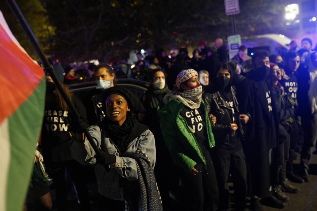 Demonstrators stand near the headquarters of the Democratic National Committee Wednesday, Nov. 15, 2023, in Washington.