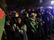 Demonstrators stand near the headquarters of the Democratic National Committee Wednesday, Nov. 15, 2023, in Washington.