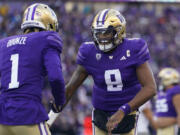 Washington quarterback Michael Penix Jr. (9) celebrates throwing a touchdown to wide receiver Rome Odunze (1) against Washington State during the first half of an NCAA college football game, Saturday, Nov. 25, 2023, in Seattle.