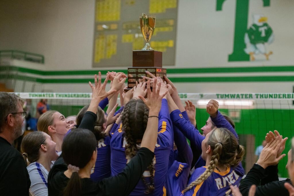 The Columbia River volleyball team hoists the championship trophy after beating Ridgefield for the 2A district title in Tumwater (Josh Kirshenbaum/Centralia Chronicle)