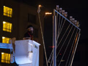 Rabbi Shmulik Greenberg leads the crowd as they celebrate the beginning of Hanukkah with the lighting of the menorah Thursday evening at Esther Short Park in downtown Vancouver.