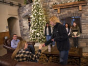 Ridgefield High School student Keaira Farley, right, hands a stamp to Windy Hills Winery director of events Ashley Miller on Tuesday during a pitch meeting for the students&rsquo; &ldquo;Ridgefield Passport&rdquo; idea at the winery in Ridgefield. The students said the project is not only an opportunity to provide a service for local businesses, but it helps them practice their marketing and business skills.