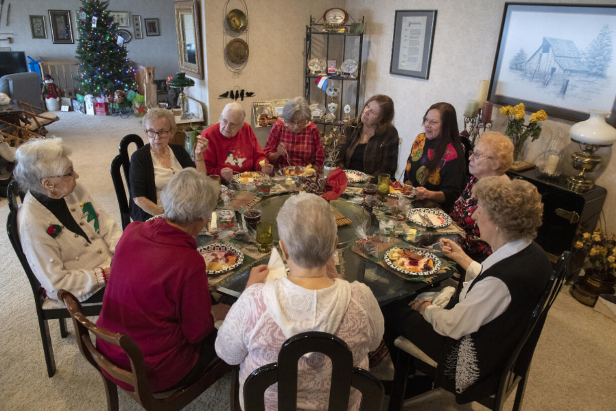 Rose Funk of Vancouver, left, hosts her former Girl Scouts troop, the Evergreen Pollyannas, for a holiday potluck on Dec. 6. The group has been meeting once a month for 75 years.