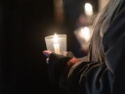 Attendees hold candles Friday, Dec. 21, 2023, during a Homeless Persons Memorial Day event at St. Paul Lutheran Church in downtown Vancouver.