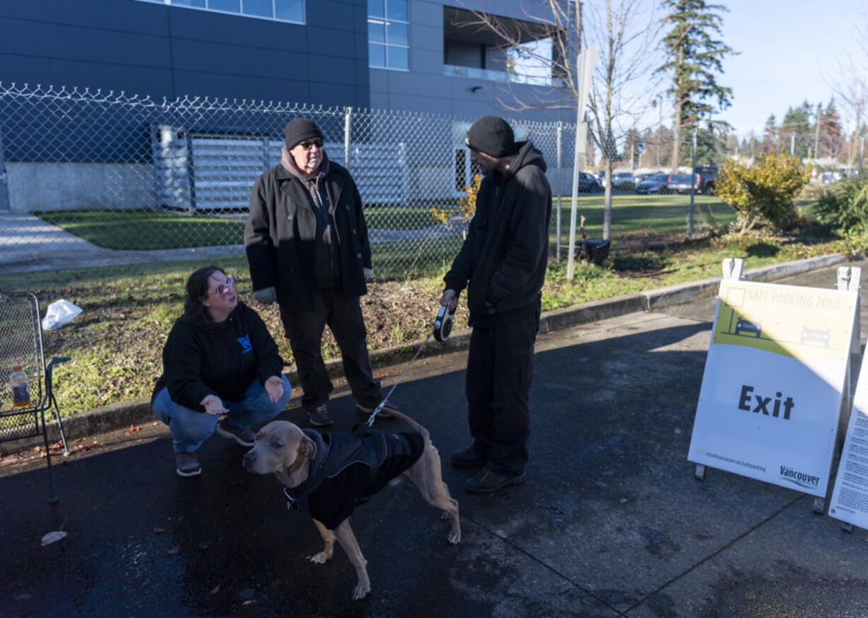 Thrive to Survive Director of Operations Erin Honan, left, and Program Manager Rick German, center, talk to Jason Nelson and dog Roach, 3. Nonprofit Thrive 2 Survive is taking over management of the program from the city. Nelson and his partner are on the waitlist to get into the parking facility.