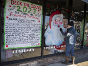 Artist Kent Huggins puts the finishing touches on a painting of Santa Claus while creating holiday scenes on businesses&rsquo; windows in downtown Vancouver for free, as seen at Center Stage Clothiers on Wednesday afternoon.