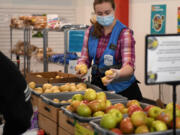 Volunteer Alisandra Parmenter restocks potatoes Friday at FISH of Vancouver. The organization set a record for number of families served this week.