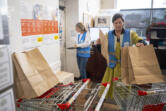 Volunteer Briette Colville, right, readies paper bags for food pantry customers Friday at FISH of Vancouver.