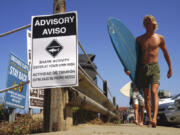 A sign warning beachgoers about shark activity is posted at the top of the trail leading down to Beacon&rsquo;s Beach in Leucadia on July 26, 2019, in Encinitas, Calif.