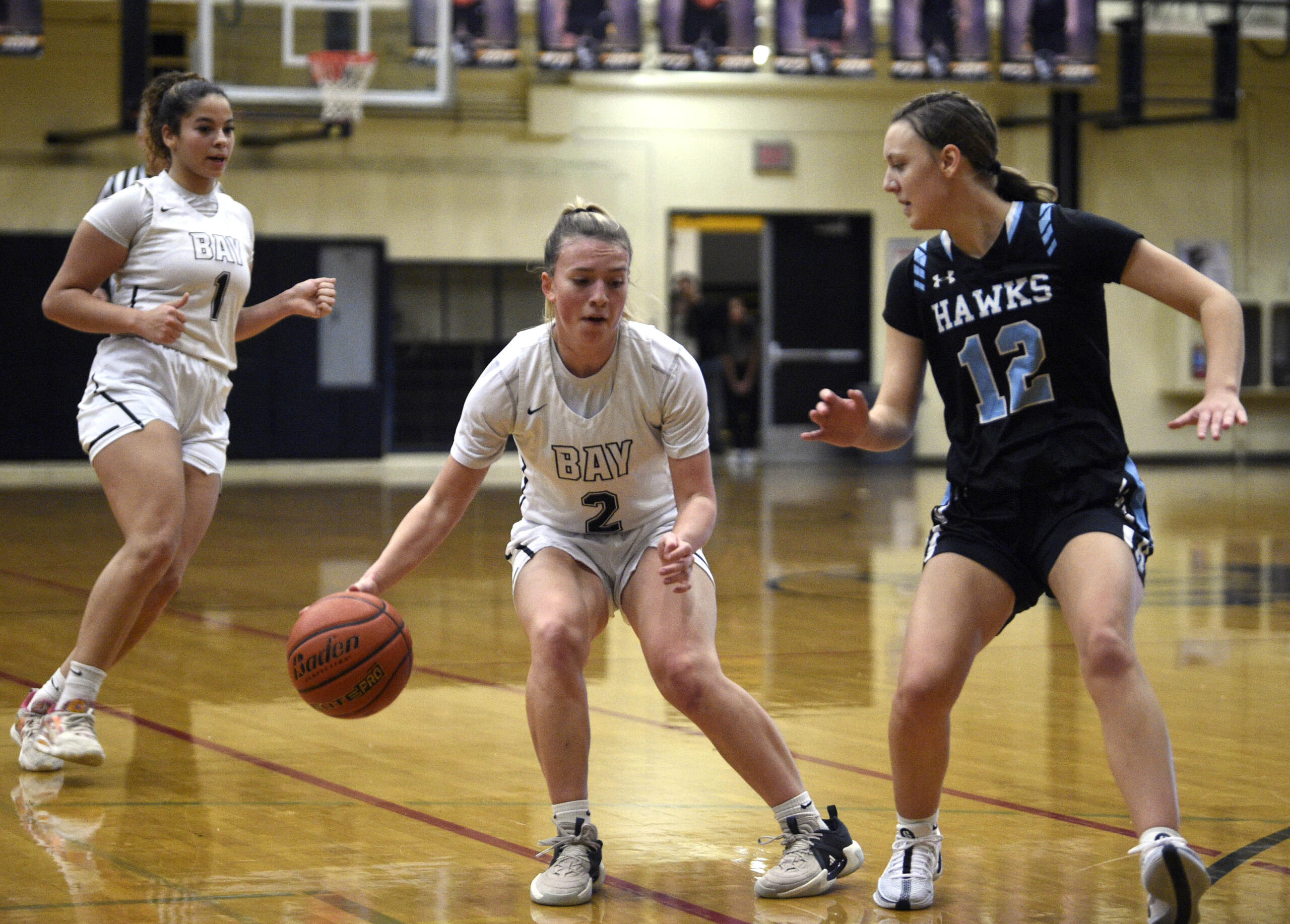 Hudson’s Bay’s Promise Bond, center, looks to change direction while dribbling against Hockinson’s Kathryn White during a 2A Greater St. Helens League girls basketball game on Friday, Dec. 8, 2023, at Hudson’s Bay High School.