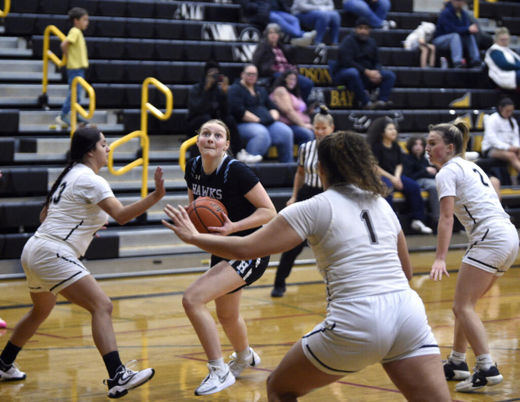 Hockinson’s Siena Brown gathers the ball and looks toward the hoop as Hudson’s Bay defenders converge during a 2A Greater St. Helens League girls basketball game on Friday, Dec. 8, 2023, at Hudson’s Bay High School.