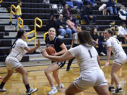 Hockinson’s Siena Brown gathers the ball and looks toward the hoop as Hudson’s Bay defenders converge during a 2A Greater St. Helens League girls basketball game on Friday, Dec. 8, 2023, at Hudson’s Bay High School.