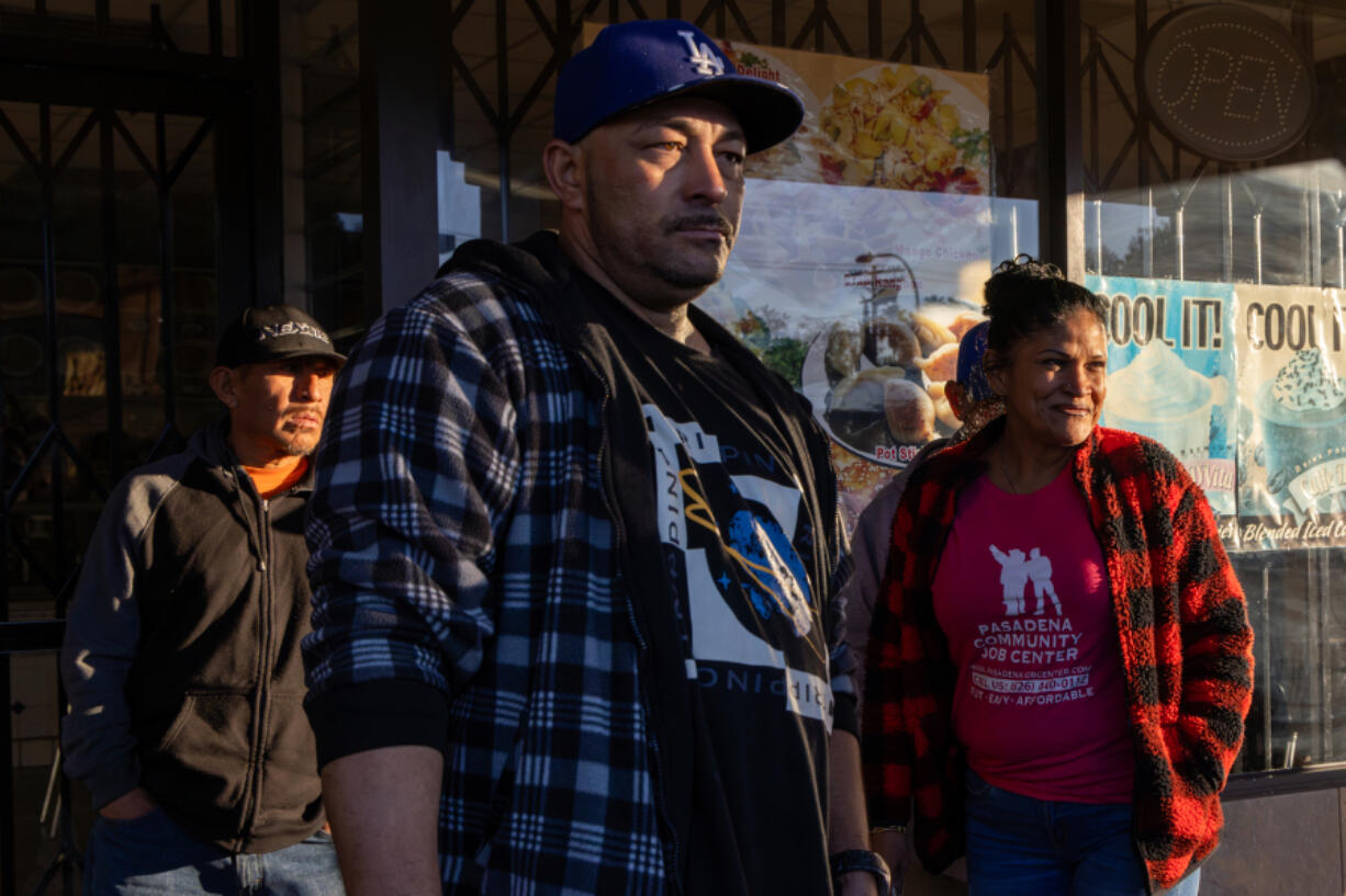 Day laborers wait for a job early morning at a shopping plaza on Friday, Nov. 17, 2023, in Pasadena, California.