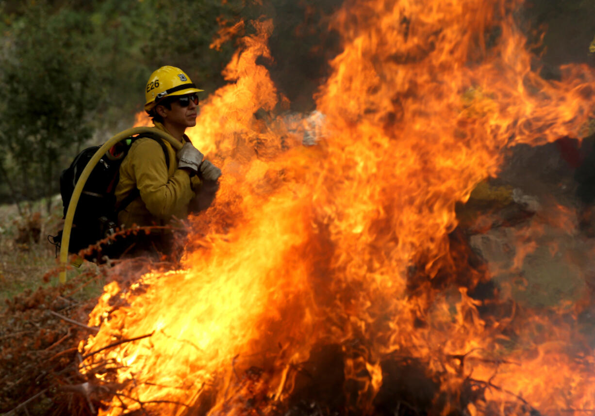 U.S. Forest Service firefighters in the Angeles National Forest burn piles of forest debris below Mt. Baldy on Wednesday, Nov. 29, 2023. Controlled burns are part of the service&rsquo;s forest management practices.