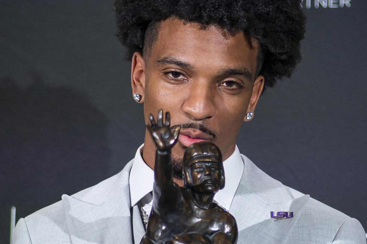 LSU quarterback Jayden Daniels kisses the Heisman Trophy during a news conference after winning the college football award, Saturday, Dec. 9, 2023, in New York.