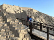 Tourists hike up into ruins of an ancient structure in Lima, Peru. Walking through neighborhoods and cityscapes is one way to better understand a nation&rsquo;s culture.