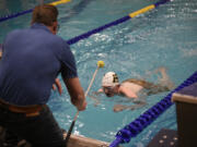 Don Johnson, left, prepares to tap his son Charles Johnson during the 200 yard individual medley race at Kelso High School on Wednesday, Dec. 20, 2023. Charles Johnson is a student at the Washington State School for the Blind who swims competitively for Hudson&#039;s Bay High School.