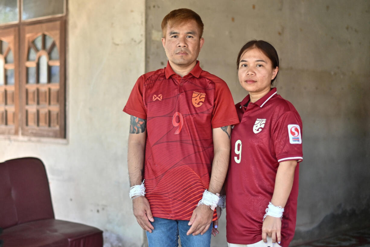 Freed Thai couple Boonthom Pankhong, left, and Natthawaree Mulkan, who were held hostage by Palestinian Hamas militants following the October 7 attack on Israel, pose for a photograph after a traditional welcoming ceremony for their safe return to Thailand at their house in Thailand&rsquo;s northeastern Udon Thani province on Dec. 6, 2023.