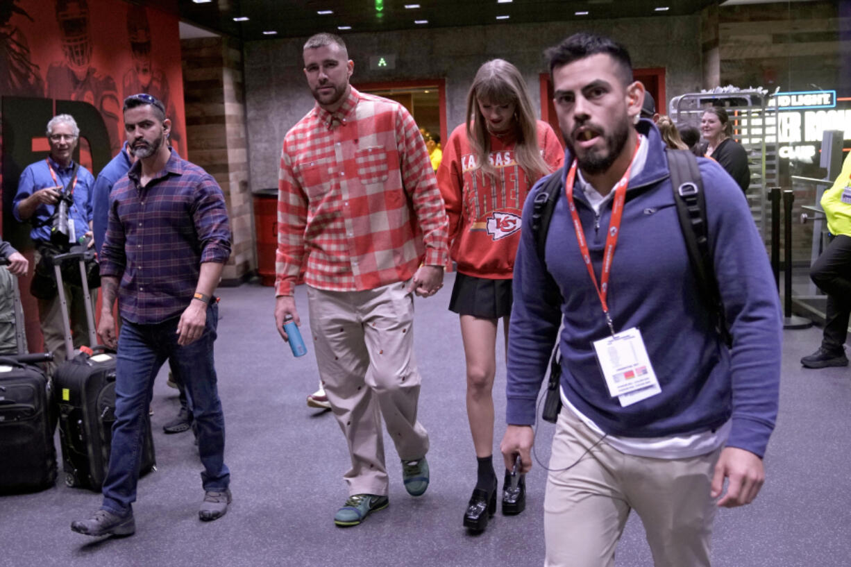 FILE - Kansas City Chiefs tight end Travis Kelce, center left, and singer Taylor Swift leave Arrowhead Stadium after an NFL football game between the Chiefs and the Los Angeles Chargers, Oct. 22, 2023, in Kansas City, Mo. A friendship bracelet with a phone number: that&rsquo;s how Kelce planned to woo Swift when he went to her Eras Tour concert stop in the Missouri capital. The romance that united sports and music fans, a celestial wonder that drew millions of eyes skyward and a long overdue homecoming for some Native American tribes were just some of the moments that inspired us and brought joy in 2023.