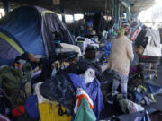 A woman gathers possessions to take before a homeless encampment was cleaned up in San Francisco, Tuesday, Aug. 29, 2023. Cities across the U.S. are struggling with and cracking down on tent encampments as the number of homeless people grows, largely due to a lack of affordable housing. Homeless people and their advocates say sweeps are cruel and costly, and there aren't enough homes or beds for everyone.