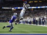 Dallas Cowboys wide receiver Brandin Cooks (3) catches a pass for a first down as Seattle Seahawks safety Jamal Adams (33) defends in the first half of an NFL football game in Arlington, Texas, Thursday, Nov. 30, 2023.