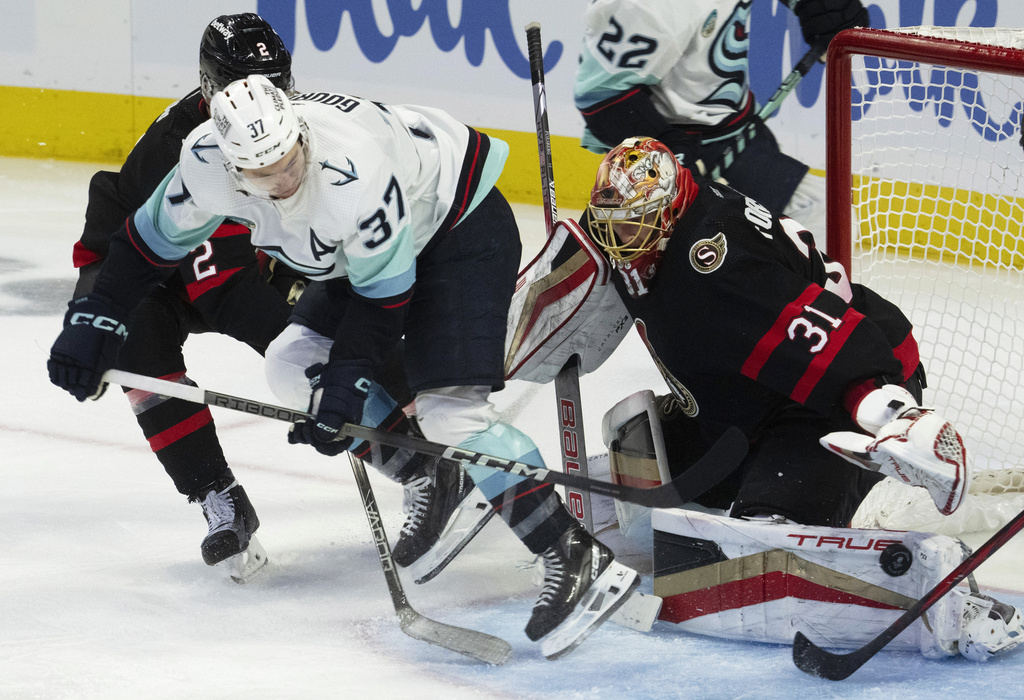 Seattle Kraken center Yanni Gourde (37) tries a backhand shot against Ottawa Senators goaltender Anton Forsberg, right, during third-period NHL hockey game action, Saturday, Dec. 2, 2023, in Ottawa, Ontario.