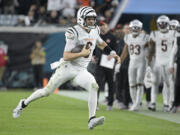 Cincinnati Bengals quarterback Jake Browning (6) runs with the football during the second half of an NFL football game against the Jacksonville Jaguars, Monday, Dec. 4, 2023, in Jacksonville, Fla. (AP Photo/Phelan M.