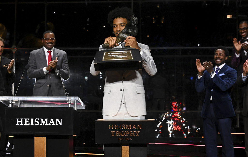 LSU quarterback Jayden Daniels lifts Heisman Trophy after winning the college football award, Saturday, Dec. 9, 2023, in New York.