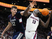 UConn center Donovan Clingan (32) vies for the ball against Gonzaga forward Graham Ike (13) during the second half of an NCAA college basketball game Friday, Dec. 15, 2023, in Seattle.