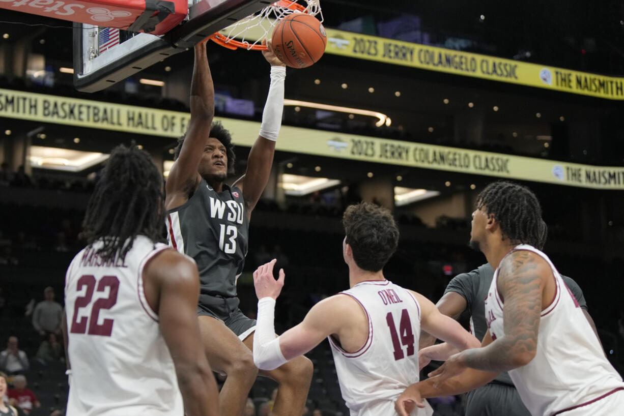 Washington State forward Isaac Jones (13) dunks over Santa Clara guard Carlos Marshall Jr. (22) and forward Johnny O'Neil (14) during the second half of an NCAA college basketball game, Saturday, Dec. 16, 2023, in Phoenix. Santa Clara won 69-61.