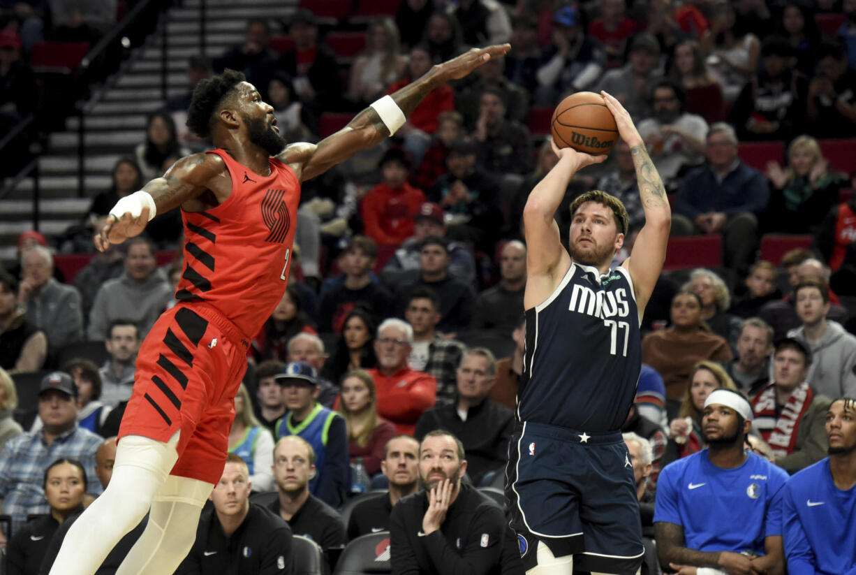 Dallas Mavericks guard Luka Doncic (77) shoots the ball as Portland Trail Blazers center Deandre Ayton defends during the first half of an NBA basketball game in Portland, Ore., Saturday, Dec. 16, 2023.