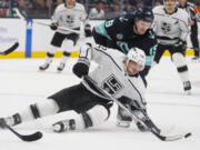 Los Angeles Kings left wing Kevin Fiala (22) tries to keep control of the puck as he falls against Seattle Kraken left wing Jared McCann (19) during the second period of an NHL hockey game Saturday, Dec. 16, 2023, in Seattle.