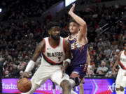 Portland Trail Blazers center Deandre Ayton, left, drives to the basket against Phoenix Suns guard Grayson Allen during the second half of an NBA basketball game in Portland, Ore., Tuesday, Dec. 19, 2023. The Blazers won 109-104.