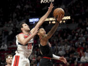 Portland Trail Blazers guard Anfernee Simons, right, drives to the basket against Washington Wizards forward Danilo Gallinari (88) during the first half of an NBA basketball game in Portland, Ore., Thursday, Dec. 21, 2023.