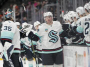 Seattle Kraken defenseman Vince Dunn, center, celebrates with teammates after his goal during the first period of an NHL hockey game against the Anaheim Ducks, Saturday, Dec. 23, 2023, in Anaheim, Calif. (AP Photo/Jae C.