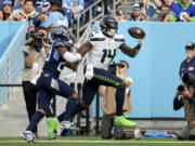 Seattle Seahawks wide receiver DK Metcalf (14) catches a touchdown pass in front of Tennessee Titans cornerback Tre Avery during the second half of an NFL football game on Sunday, Dec. 24, 2023, in Nashville, Tenn.