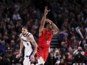 Portland Trail Blazers guard Scoot Henderson, right, celebrates his 3-pointer against the Sacramento Kings during the second half of an NBA basketball game Tuesday, Dec. 26, 2023, in Portland, Ore.
