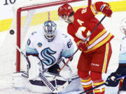 Seattle Kraken goalie Chris Driedger makes a save against Calgary Flames' Elias Lindholm during the third period of an NHL hockey game Wednesday, Dec. 27, 2023, in Calgary, Alberta.