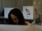 FILE - A voter in the foreground casts her ballots during the Republican primary election in Wilson, Wyo., Aug. 16, 2022. Relatively few Americans are excited about a potential rematch of the 2020 election between President Joe Biden and Donald Trump. But more Republicans would be happy to have Trump as their nominee than Democrats would be with Biden. That&rsquo;s according to a new poll from The Associated Press-NORC Center for Public Affairs Research. (AP Photo/Jae C.