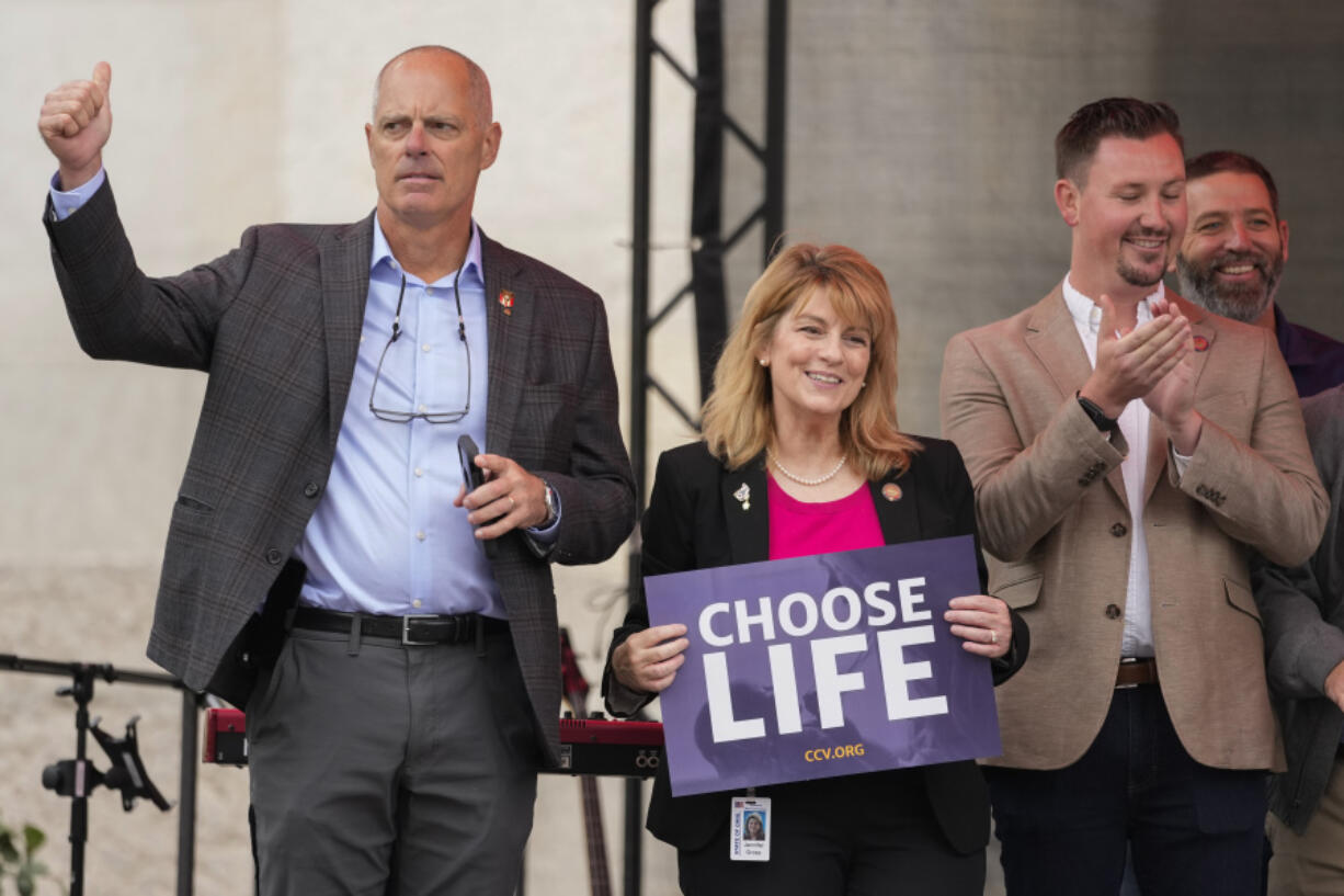 Ohio State Rep. Jennifer Gross, R-West Chester, holding a &ldquo;Choose Life&rdquo; sign, center, joined by Ohio State Rep. Adam Bird, R-New Richmond, left, and Ohio State Rep. Thomas Hall, R-Madison Township, right, stand together on stage during the Ohio March for Life rally at the Ohio State House in Columbus, Ohio, Oct. 6, 2023. The statewide battles over abortion rights that have erupted since the U.S. Supreme Court overturned a constitutional right to the procedure have exposed another fault line: commitment to democracy.