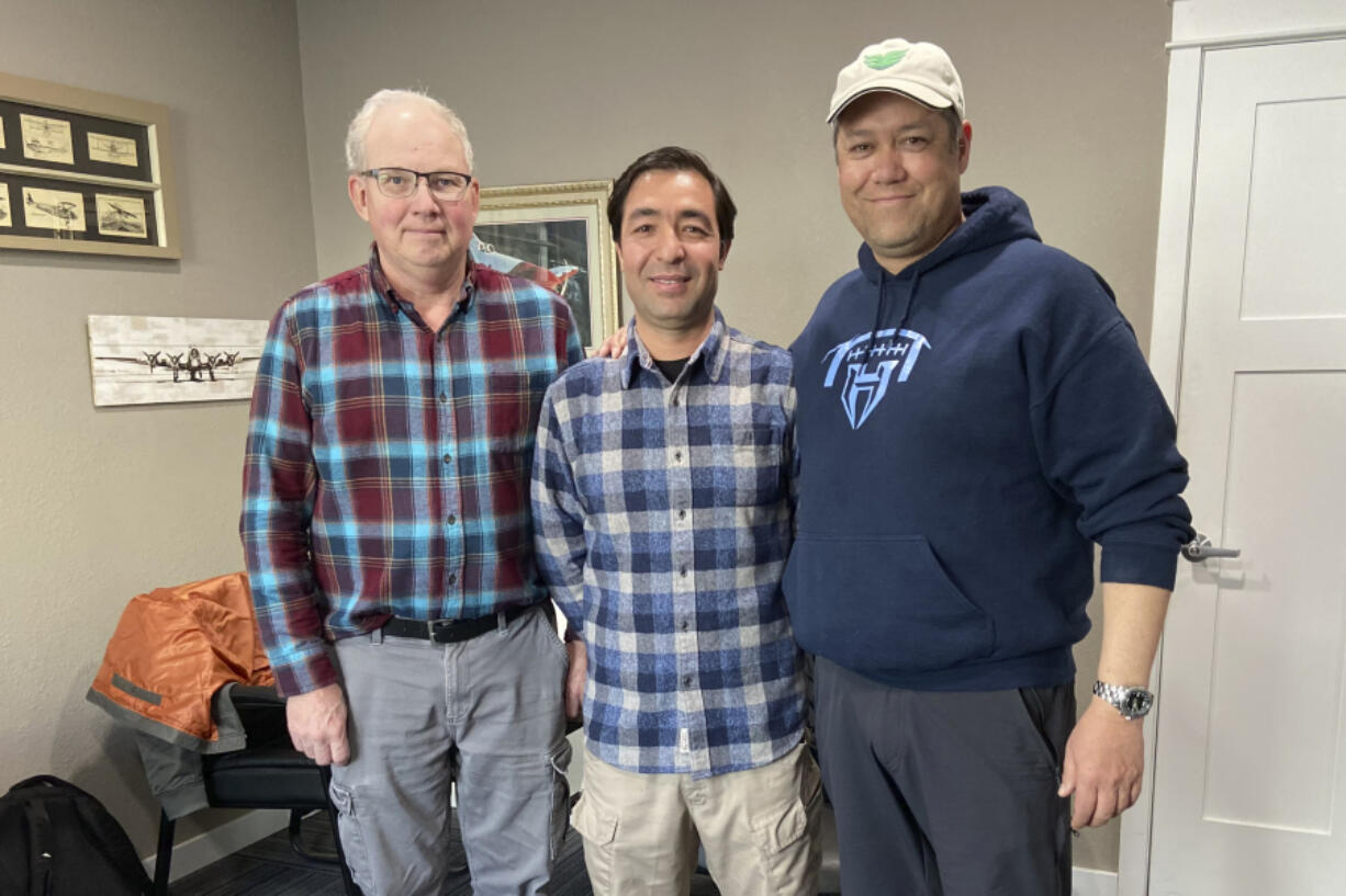 In this photo provided by Nikki Chung, Mohammad Hussain Musawi, center, stands with his flight instructor, left, and Darin Chung, co-founder of the Afghan American Development Group, a nonprofit that helps former Afghan military aviation personnel with refugee resettlement assistance in the U.S., at a flight hangar in Independence, Ore. on April 7, 2023. Musawi and two other Afghan Air Force pilots lost their lives when a small plane that he was piloting crashed near Independence on Dec. 16, 2023.