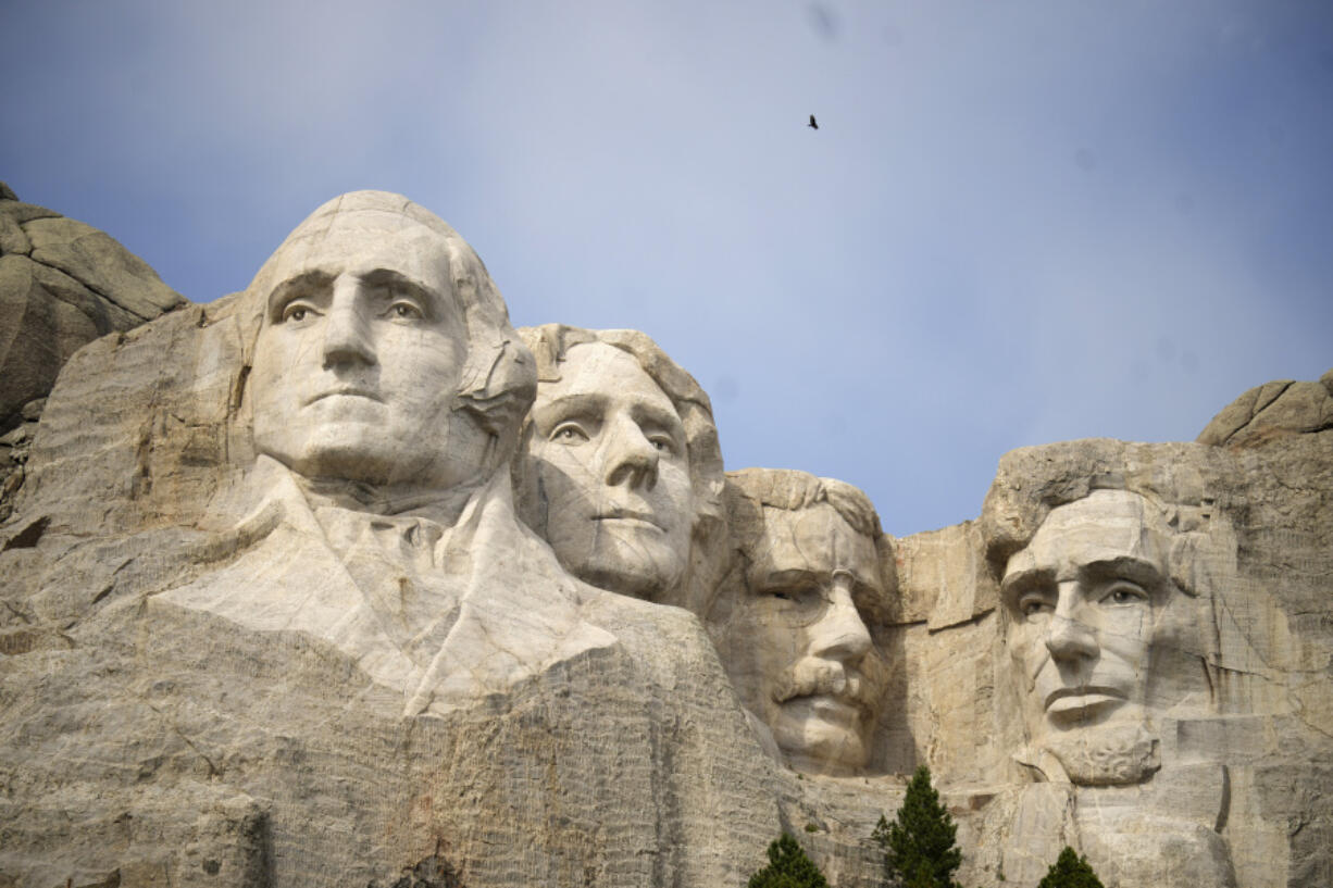 Visitors take in the massive sculpture carved into Mount Rushmore at the Mount Rushmore National Memorial on Sept. 21 in, Keystone, S.D. Fewer planes and helicopters will be flying tourists over Mount Rushmore and other national monuments and parks as new regulations take effect that are intended to protect the serenity of some of the nation&rsquo;s most beloved natural areas.